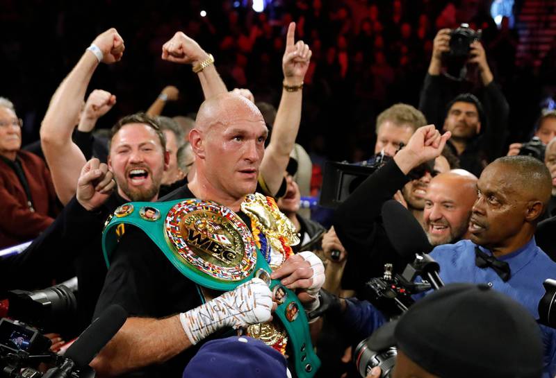 Tyson Fury celebrates with the belts after winning the fight.