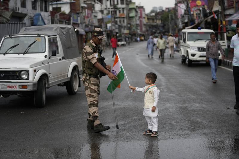 A child presents an Indian flag to a member of the security forces to mark Independence Day in Jammu, in Jammu and Kashmir. AP Photo
