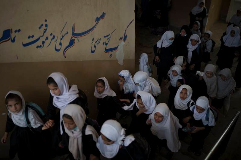 Girls walk upstairs as they enter a school before class in Kabul. AP