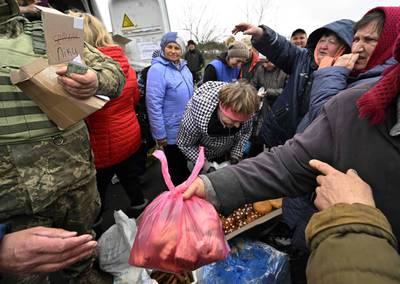 Volunteers distribute food to residents in Zalissya. AFP