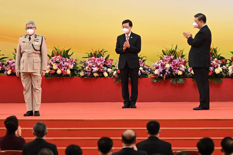Mr Xi and Mr Lee clap as Hong Kong's director of immigration Au Ka-wang, left, is sworn in. AFP