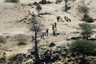 FILE PHOTO: Ethiopians fleeing from the Tigray region walk towards a river to cross from Ethiopia to Sudan, near the Hamdeyat refugee transit camp, which houses refugees fleeing the fighting in the Tigray region, on the border in Sudan, December 1, 2020. REUTERS/Baz Ratner/File Photo
