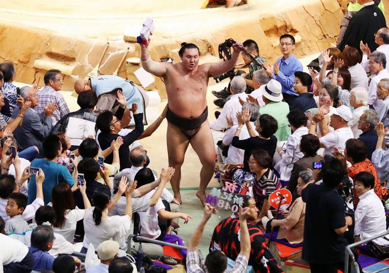 Mongolian-born sumo grand champion Hakuho (C) receives the blessing from spectators after he established all-time sumo record with his 1,048th win, at the 13rd day of the 15-day Nagoya Grand Sumo Tournament at the Aichi Prefectural Gymnasium in Nagoya, central Japan, in this photo taken by Kyodo July 21, 2017. Mandatory credit Kyodo/via REUTERS ATTENTION EDITORS - THIS IMAGE WAS PROVIDED BY A THIRD PARTY. MANDATORY CREDIT. JAPAN OUT. NO COMMERCIAL OR EDITORIAL SALES IN JAPAN.