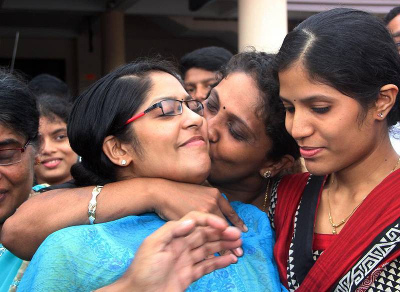 An Indian nurse, left, is greeted by a relative after arriving at Kochi airport in the southern state of Kerala on Saturday. A group of 46 Indian nurses who were trapped in an area of Iraq seized by Islamic militants were greeted by tears and cheers from relatives as they arrived home in southern India. AFP