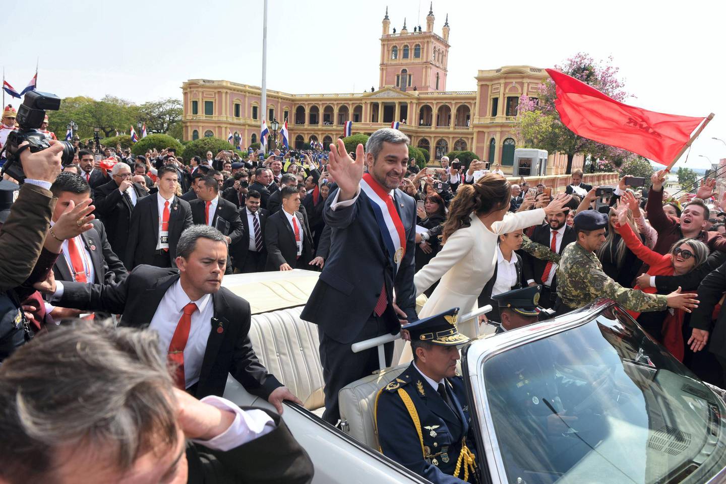 Paraguay's new President Mario Abdo Benitez and his wife Silvana Lopez head to the Cathedral on a 1967 Cadillac convertible after the swearing-in ceremony at the presidential palace in Asuncion, on August 15, 2018. / AFP PHOTO / Daniel DUARTE