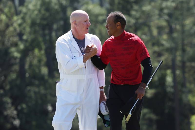 Tiger Woods and caddie Joe LaCava shake hands on the 18th green after finishing their round of the Masters. Getty
