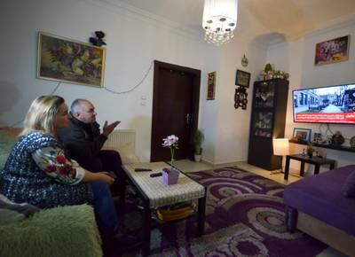 Tatiana and Wessam Al Awamleh, whose daughter Diana is studying in Ukraine, watch a television report on the conflict at their home in Amman. Reuters