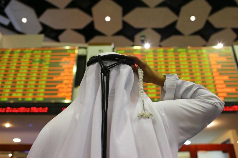A visitor holds prayer beads while looking at financial information screens at the Dubai Financial Market (DFM) in Dubai, United Arab Emirates, on Tuesday, Nov. 10, 2015. Dubai's index declined for three straight months after a collapse in the price of crude battered economies in the oil-producing nations of the Gulf Cooperation Council. Photographer: Jasper Juinen/Bloomberg