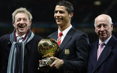 Manchester United's Cristiano Ronaldo, centre, holds the Ballon d'Or trophy, as former United players Denis Law, left, and Bobby Charlton, right, look on in 2008. AP