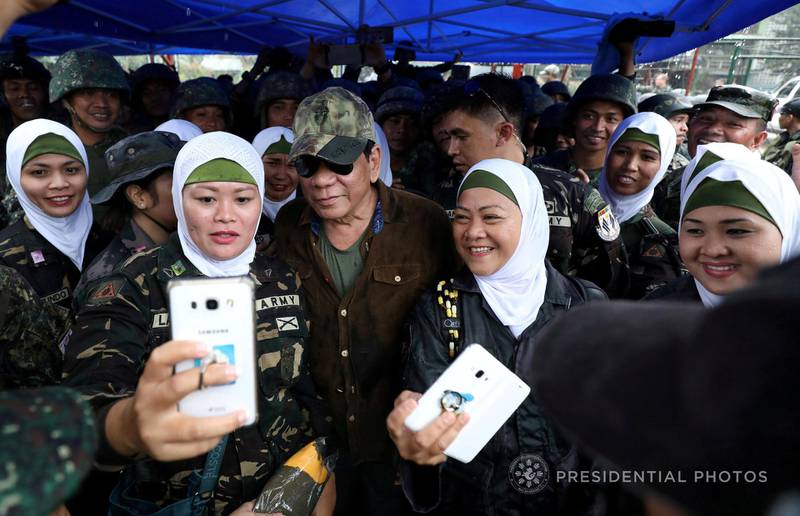 FILE PHOTO: Philippine President Rodrigo Duterte (C) poses for a picture with female soldiers during his visit at Bangolo town in Marawi city, southern Philippines October 17, 2017.  Malacanang Presidential Photo/Handout via REUTERS/File Photo  THIS IMAGE HAS BEEN SUPPLIED BY A THIRD PARTY. NO RESALES. NO ARCHIVES