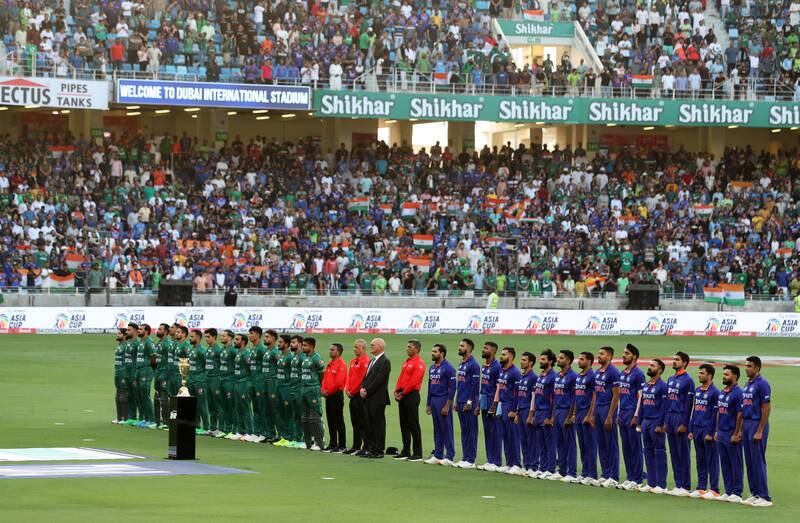 The teams stand for the national anthems before the start of the game.