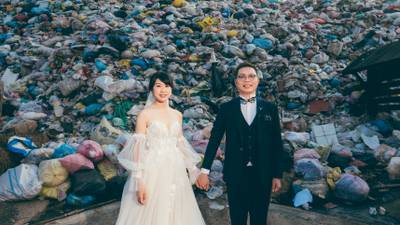 Iris Hsueh, left, and her fiance Ian Ciou pose for a pre-wedding photo in front of a rubbish heap in Puli Township, Taiwan. The couple chose the site for their photoshoot because the environment-conscious bride said she wanted to discourage guests and the public from generating waste.  AFP