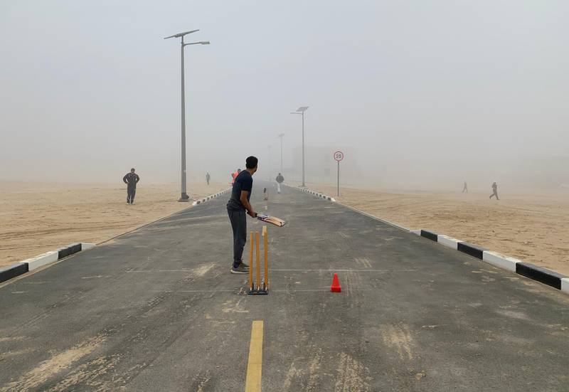 Cricket fans play street cricket during the early morning fog in the Al Furjan area of Dubai. Pawan Singh / The National