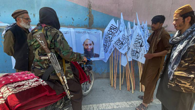 Members of Taliban forces gather around a picture of their leader Mawlawi Hibatullah Akhundzada, in Kabul on August 25, 2021. Reuters