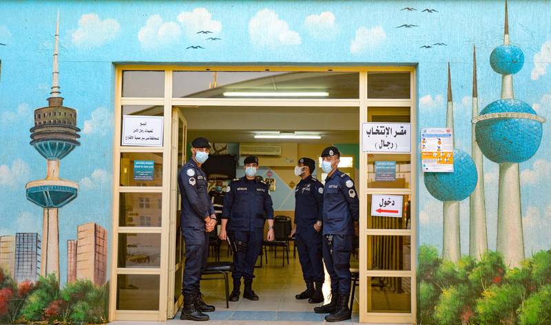 Kuwaiti police officers stand at the entrance of a polling station in Kuwait City. EPA