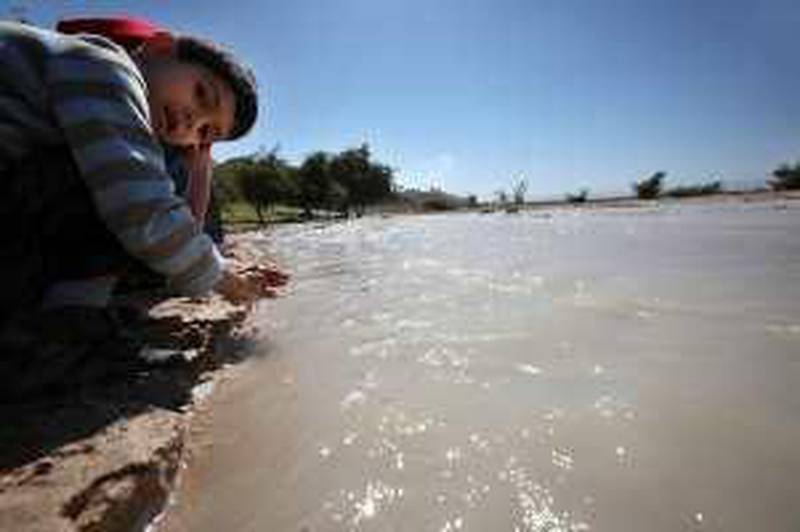 Children play with water that floods into the Wadi Shuaib dam near south Shuneh on March 21, 2010. (Salah Malkawi for The National)