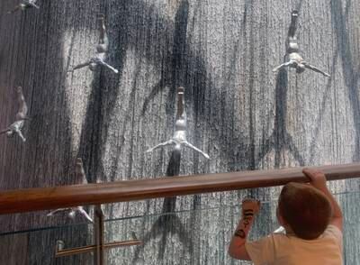 A young boy looks at the waterfall in Dubai Mall, Dubai. Chris Whiteoak / The National