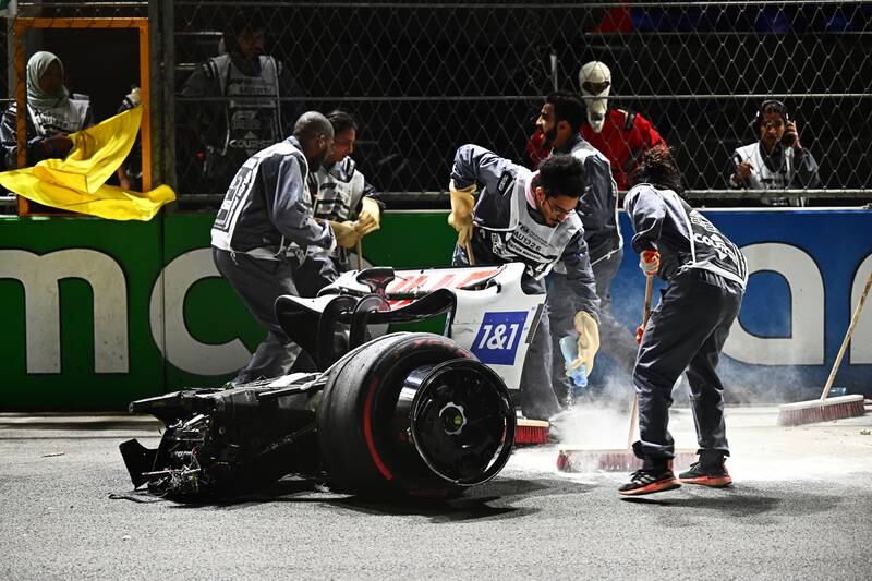 Track marshals clean debris from the track following Schumacher's crash. Getty