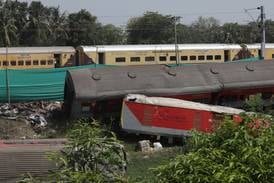 A passenger train (back) runs past the wreckage of a train following an accident at Odisha Balasore, India, 05 June 2023.  Over 280 people died and more than 900 were injured following a three-train collision in the eastern Indian state of Odisha on 02 June 2023.  A passenger train derailed and crashed into a freight train, sending debris onto another track and hitting a third train that was coming down in the opposite direction.   EPA / PIYAL ADHIKARY