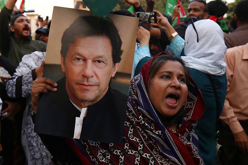 A supporters holds a portrait of Mr Khan. EPA