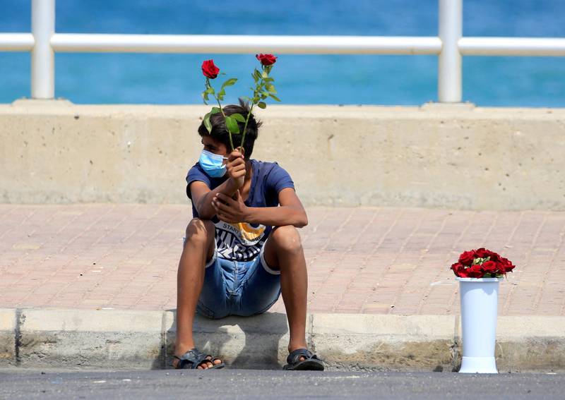 A street vendor wearing a mask sells roses in Sidon, Lebanon. Reuters