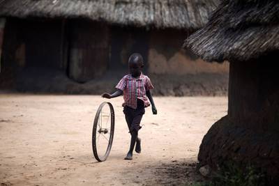 A South Sudanese child plays in a street after visiting a mobile clinic in Rejaf on October 24, 2015. The UN agencies such as UNICEF, WHO and WFP, among others, conducted an inter-agency operation in the village, to give medical examination to the population, evaluate the level of malnutrition, distribute mosquito nets and food and deliver vaccination to children against poliomyelitis and measles, two of the most common causes of death among children in South Sudan. This operation was conducted to commemorate the 70th anniversary of the United Nations. AFP PHOTO / ALBERT GONZALEZ FARRAN (Photo by ALBERT GONZALEZ FARRAN / AFP)