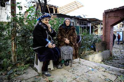 Women, whose houses are damaged, sit near the blast site hit by a rocket during the fighting over the breakaway region of Nagorno-Karabakh in the city of Ganja, Azerbaijan. Reuters