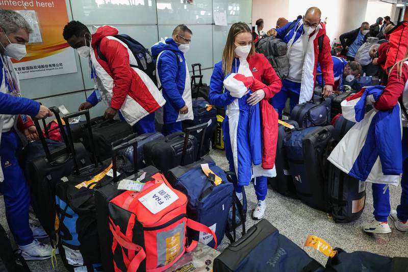 Members of the French Olympics team receive their luggage at the Beijing Capital International Airport. AP