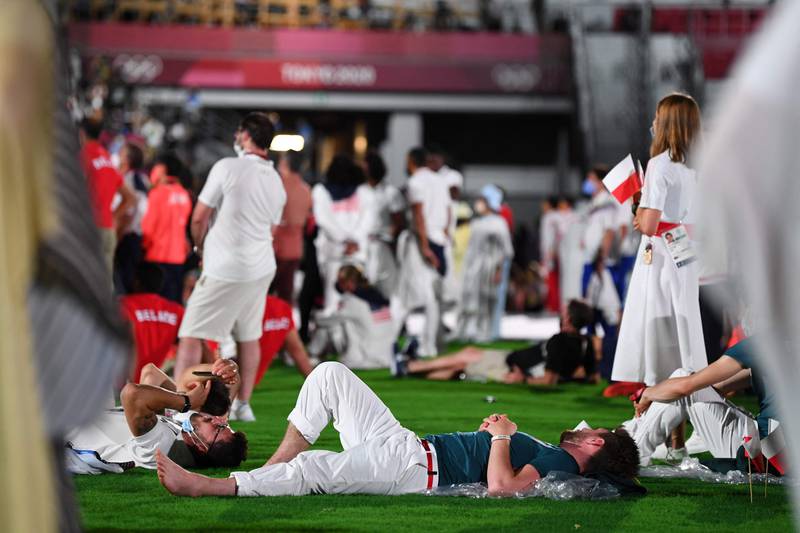 Athletes take a break during the closing ceremony of the Tokyo 2020 Olympic Games.