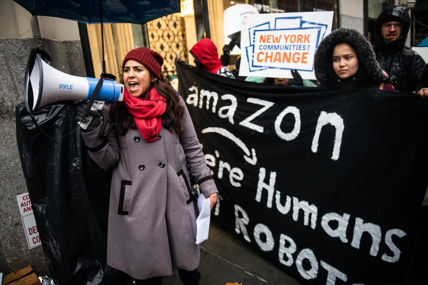 A demonstrator shouts slogans into a megaphone outside the penthouse of Jeff Bezos, founder and chief executive officer of Amazon.Com Inc., during a protest against Amazon in New York, U.S., on Monday, Dec. 2, 2019. The optics war between Amazon.com Inc. and its critics is intensifying on Cyber Monday with labor, environmental and digital privacy groups staging events around the globe to amplify their concerns about the world's biggest online retailer. Photographer: Mark Kauzlarich/Bloomberg