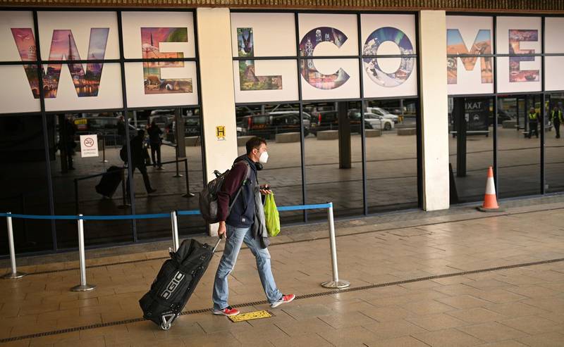 A passenger pulls their luggage after arriving at Terminal 1 of Manchester Airport. AFP