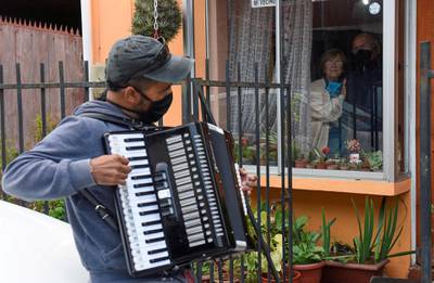 Gonzalo Acuna plays his accordion to lift his parents' spirits  in Concepcion, Chile. Reuters