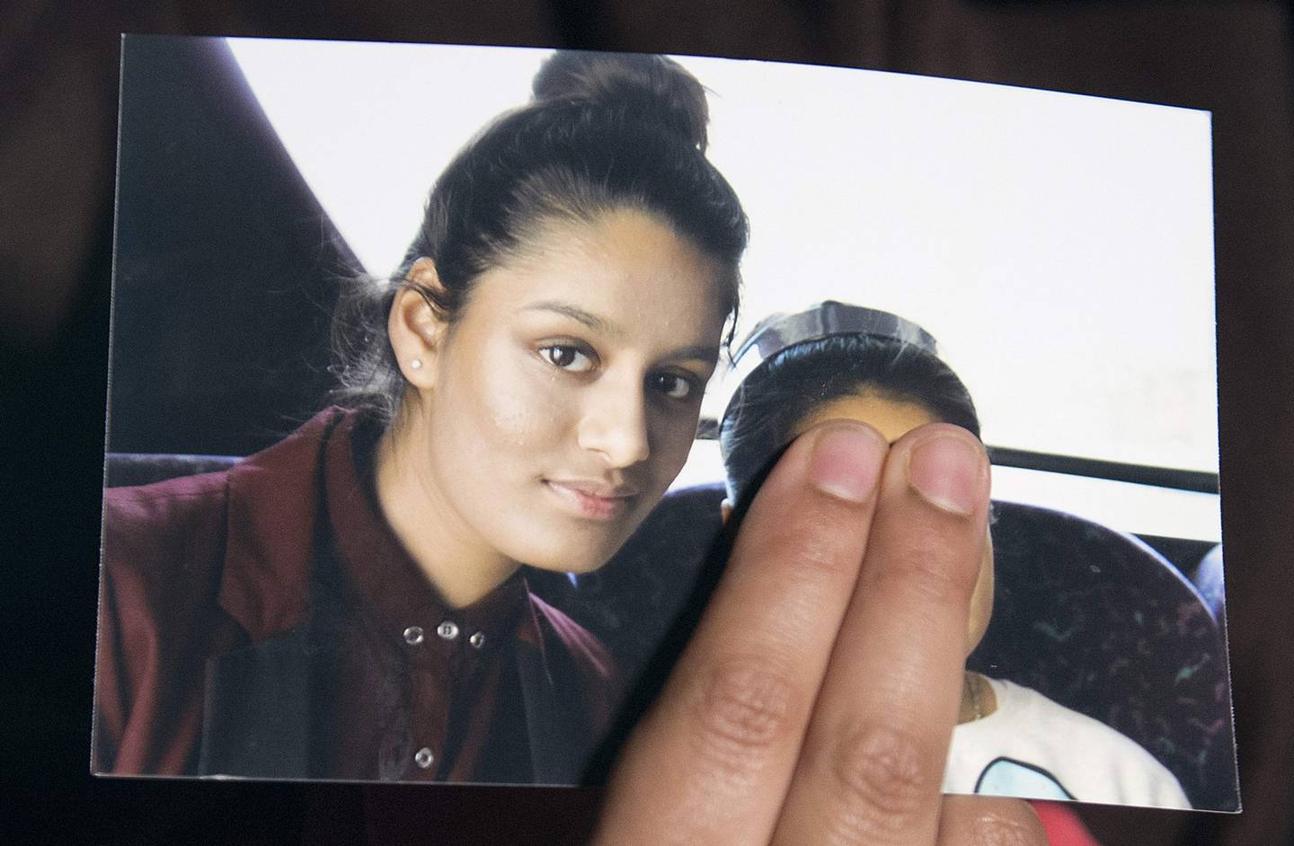 (FILES) In this file photo taken on February 22, 2015, Renu Begum, eldest sister of missing British girl Shamima Begum, holds a picture of her sister while being interviewed by the media in central London. The father of British teenager Shamima Begum, who went to Syria and married an Islamic State militant, insisted in an interview with AFP on February 25, 2019 that Britain must take her back before deciding any punishment. / AFP / POOL / POOL / LAURA LEAN
