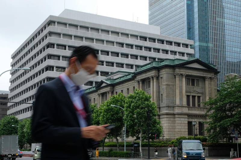 A man wearing a face mask walks past the Bank of Japan headquarters in Tokyo on May 22, 2020. Japan's central bank on May 22 offered hundreds of billions of dollars in additional lending to help small firms in the world's third-largest economy struggling with the economic devastation wrought by coronavirus. / AFP / Kazuhiro NOGI
