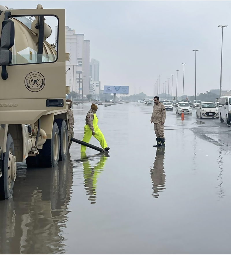 Municipal workers try to drain a road. Kuwait News Agency
