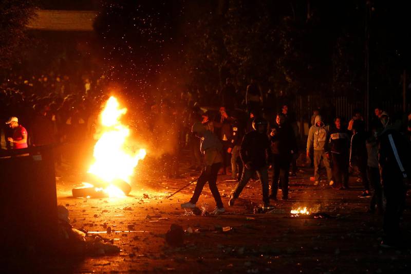 Demonstrators crowd around a stack of tires set on fire during a protest at the Corniche al Mazzraa in Beirut, Lebanon. REUTERS
