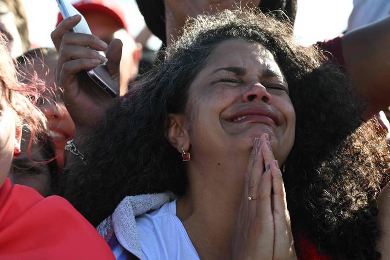 A supporter of President Luiz Inacio Lula da Silva is overcome with emotion, near the National Congress. AFP