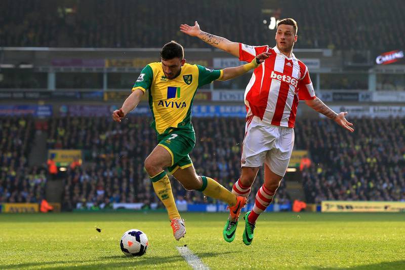 Robert Snodgrass of Norwich City goes past Geoff Cameron of Stoke City during their Premier League match at Carrow Road on March 8, 2014 in Norwich, England.  Matthew Lewis/Getty Images