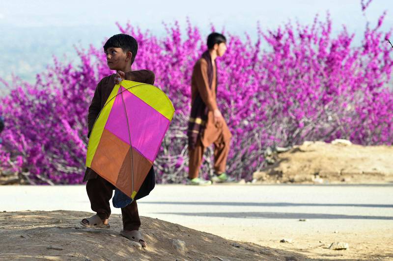 A boy carries a kite at the park, situated in Parwan province.
