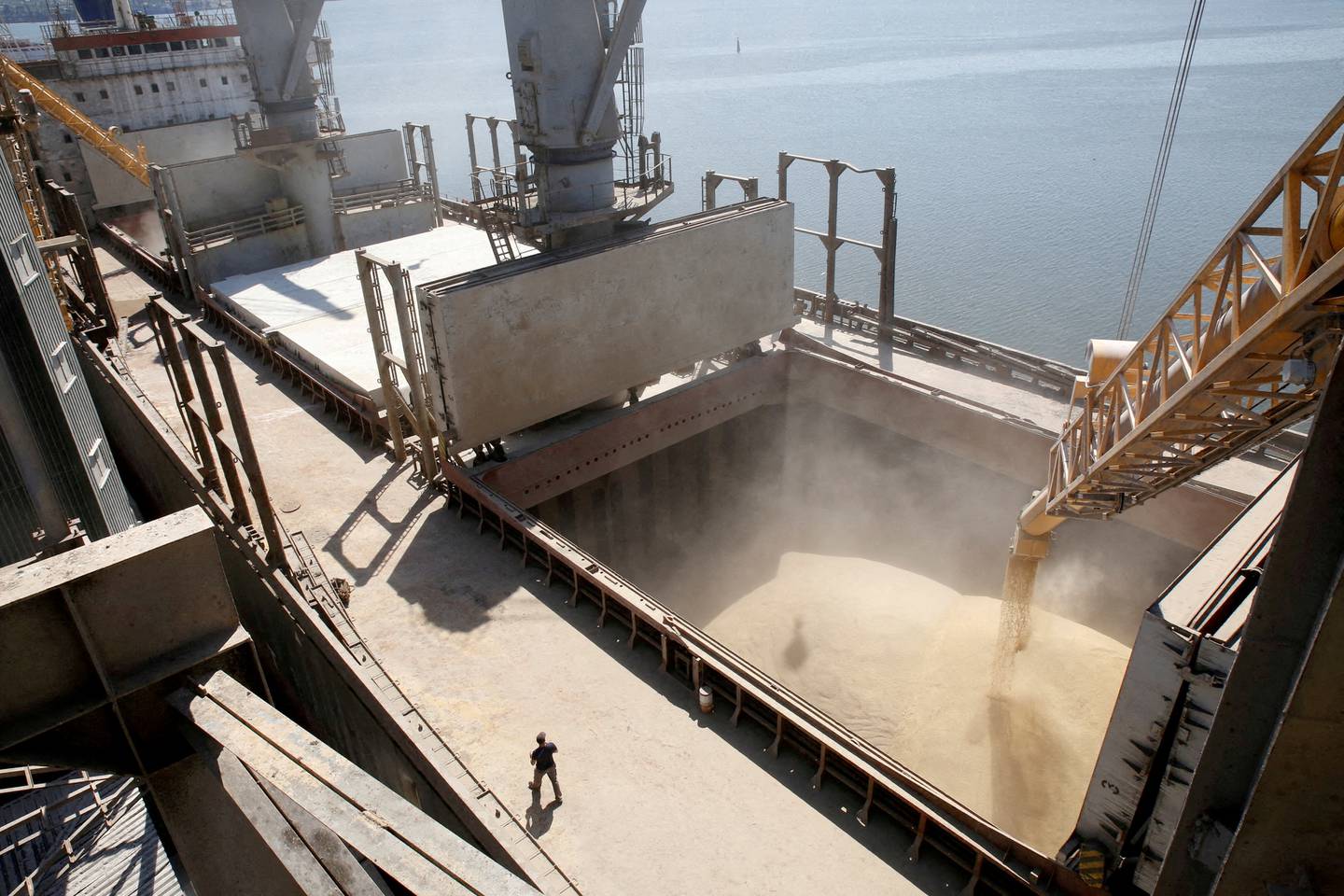 A dockyard worker watches as barley grain is mechanically poured into a 40,000 tonne ship in Nikolaev, Ukraine. Since the start of the war, weekly port calls have gone from 60 to almost zero in Ukraine. Reuters/ File  