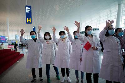 Medical workers wave goodbye to a medical team from Jilin at the Wuhan Tianhe International Airport after travel restrictions were lifted. Reuters