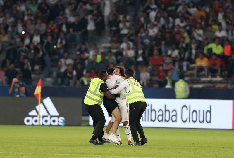 Abu Dhabi, United Arab Emirates - December 19, 2018: A pitch invader hugs Marcelo of Real Madrid during the game between Real Madrid and Kashima Antlers in the Fifa Club World Cup semi final. Wednesday the 19th of December 2018 at the Zayed Sports City Stadium, Abu Dhabi. Chris Whiteoak / The National