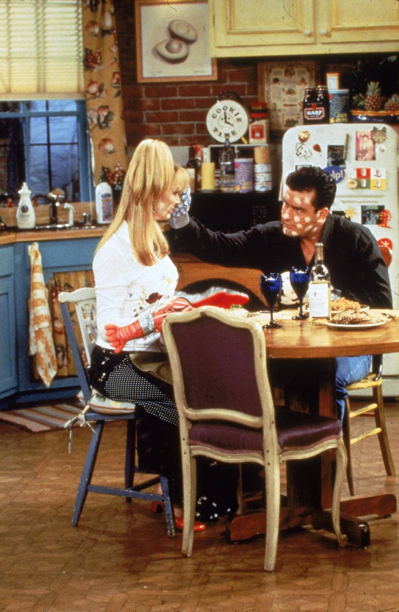 Actors Lisa Kudrow and Charlie Sheen sit at a kitchen table, with white spots on their faces, in a still from the television series, 'Friends,' circa 1996. (Photo by Fotos International/Getty Images)