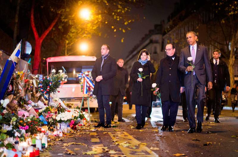 US president Barack Obama pays his respects with French president Francois Hollande and Paris Mayor Anne Hidalgo at a memorial outside the Bataclan venue in Paris in 2015.  AFP