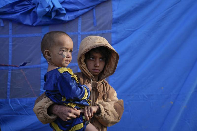 Afghan children stand in front of a tent in Gayan village after the earthquake destroyed several homes. AP