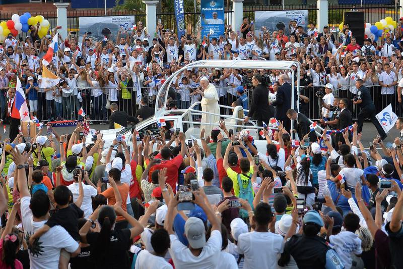 Pope Francis waves to faithfuls from the popemobile, moments after landing at Panama's Tocumen International Airport. AFP