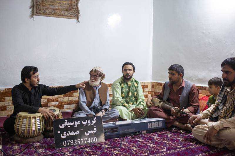 A group of musicians sit with their musical instruments and a placard with their group name and phone number at a flat of one of the musicians on Kharabat Street, old Kabul. Many musicians have been living and playing at live parties in the area. All photos: Asmaa Waguih