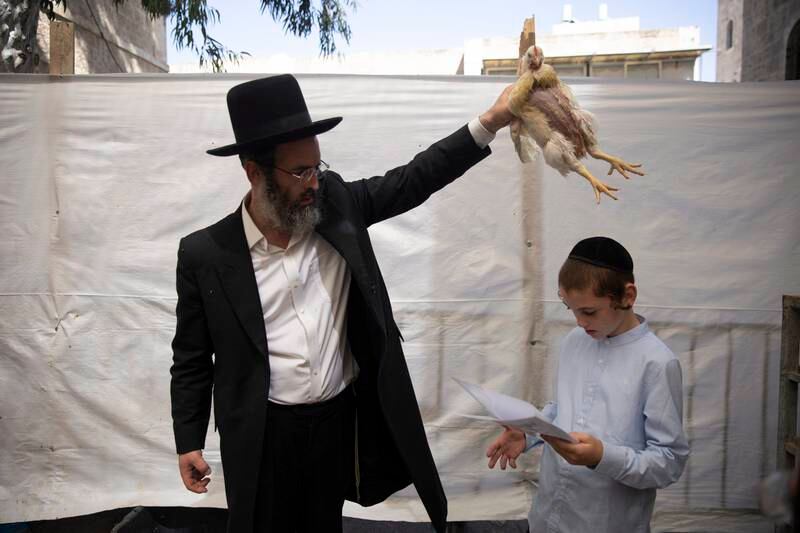 A man swings a chicken as part of the Kapparot ritual in the Mea Shearim district of Jerusalem. After the act is performed, the bird is slaughtered and donated to charity. EPA