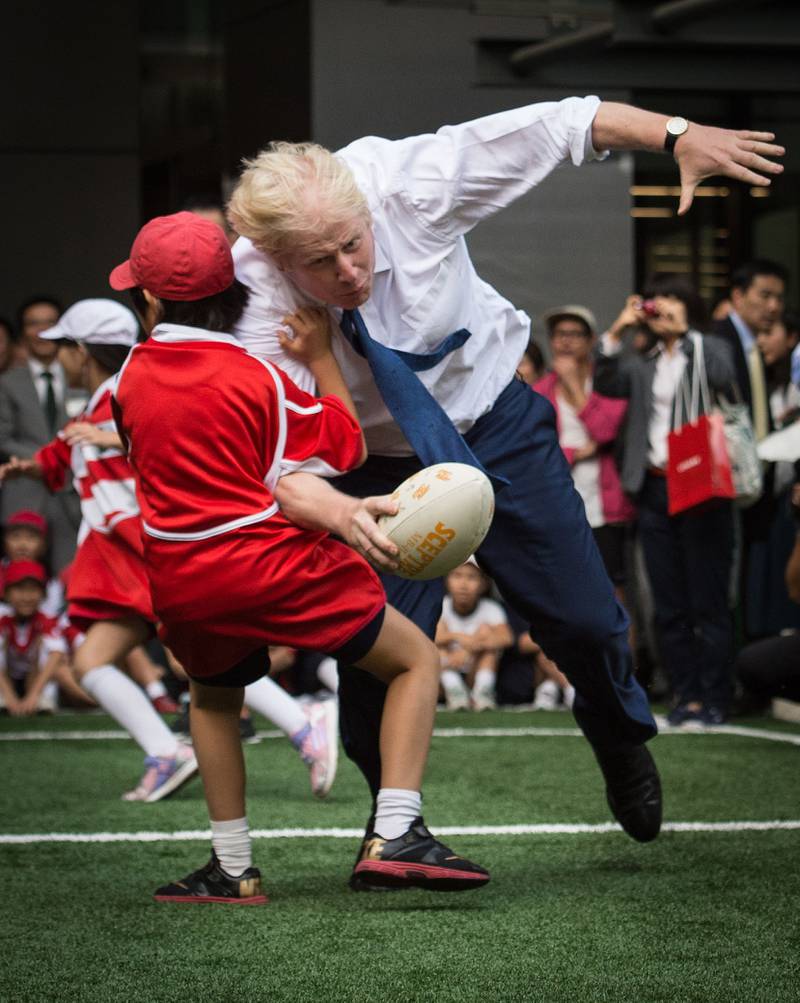 Mr Johnson bumps into a child during a Street Rugby tournament in Tokyo in 2015, held to mark Japan hosting 2019 Rugby World Cup.