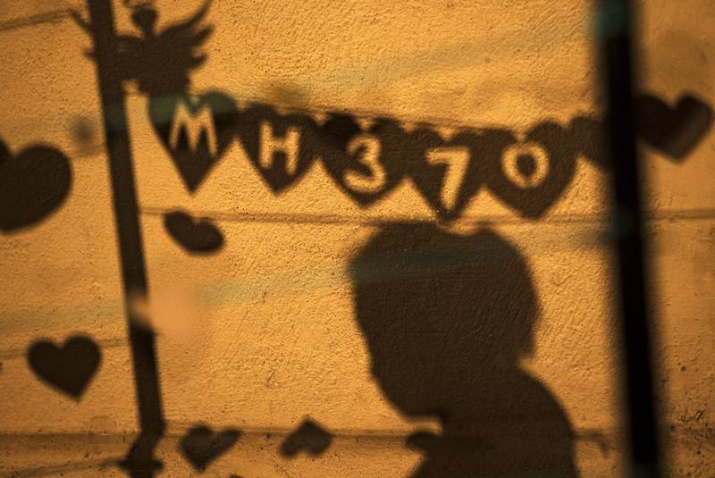 A shadow shows a person hanging a message during an event ‘Love U MH370’ in Kuala Lumpur. EPA